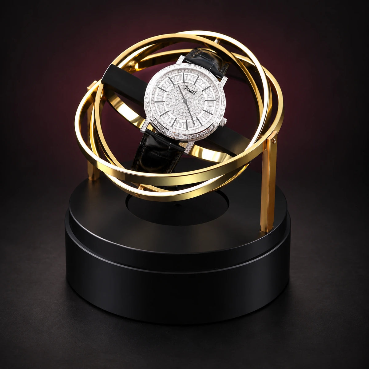 Orbit gold-tone gyroscopic watch winder with the dome removed, showing its rotating rings and a demonstration watch, not included.